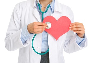 Dottore con un cuore di carta in mano