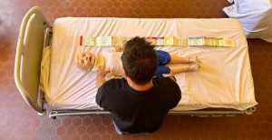 Infermiere con manichino impegnato in dimostrazione pratica